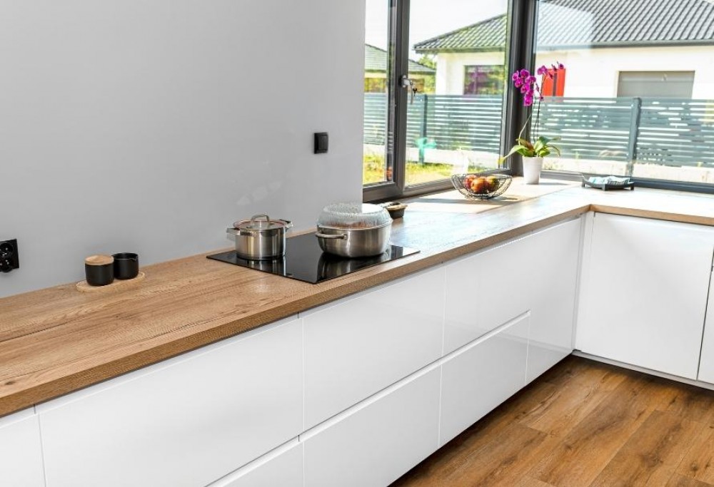 Cocina blanca con encimera de madera.